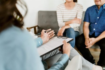 couple sitting on a sofa in a therapist's office during a marriage counseling session